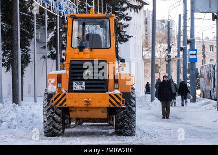 Yaroslavl, Russia. 02.01.2022. Un trattore spazzaneve si sgombero su una strada innevata . Foto di alta qualità Foto Stock