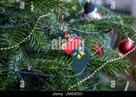 decorazione di calza di natale del legno appeso ad un albero di natale del pino norweigan Foto Stock