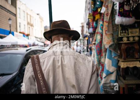 Uomo anziano che indossa un cappello a piedi in London Street Foto Stock