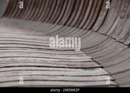 Linee ondulate di legno e pietra come sfondo grigio e marrone, strisce curve come sfondo Foto Stock