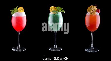 Cocktail analcolici di diversi colori in bicchieri da cocktail con menta, ciliegia e ghiaccio. Isolati sul nero Foto Stock