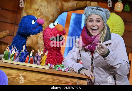 Erfurt, Germania. 08th Dec, 2022. Singa Gätgens, che ospita la "Kika Treehouse", e i personaggi di Sesame Street GROBI (l) ed Elmo si trovano ad un appuntamento fisso durante le riprese in uno studio di MDR Landesfunkhaus Thüringen. Il 8 gennaio 2023, 'Sesame Street' festeggerà il suo 50th° compleanno. Per questo sono in corso le riprese degli episodi di compleanno di 'Kika Treehouse'. Credit: Martin Schutt/dpa/Alamy Live News Foto Stock