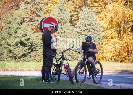 Due motociclisti di mezza età con breve riposo in cima all'edificio, stile di vita ecologico in sincronia con l'ambiente e la natura Foto Stock