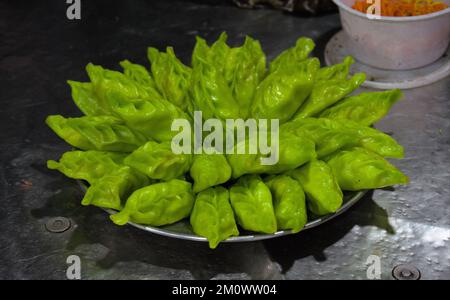 Green Momos o gnocchi chiamati 'Gondhoraj Momo' è viral Street food di Kolkata. Realizzato con un limone speciale chiamato Gondhoraj, "re dell'aroma" Foto Stock