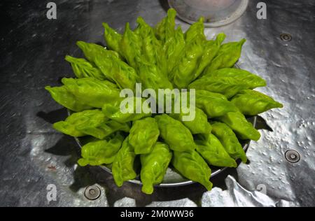 Green Momos o gnocchi chiamati 'Gondhoraj Momo' è viral Street food di Kolkata. Realizzato con un limone speciale chiamato Gondhoraj, "re dell'aroma" Foto Stock