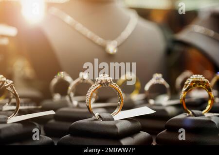 Gioielli anelli con diamanti e collane mostrano in luxury retail store window display vetrina Foto Stock