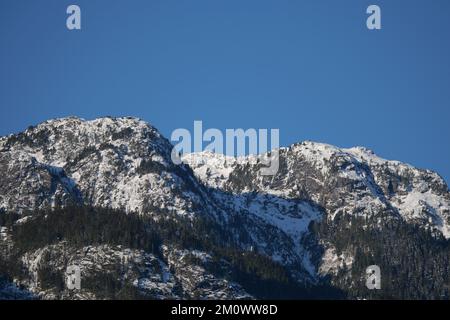 La catena montuosa innevata del Tantalo si vede dalla diga Eagle Run di Brackendale, Squamish, British Columbia, Canada Foto Stock