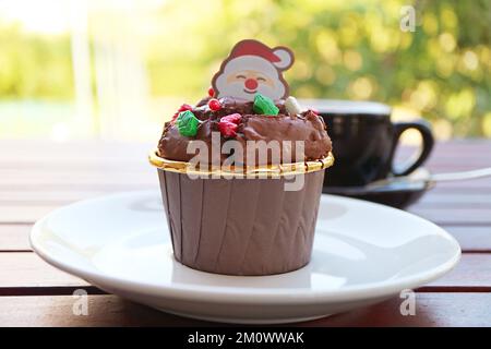 Primo piano della torta al cioccolato sormontata da Babbo Natale Candy e Christmas Sprinkles Foto Stock