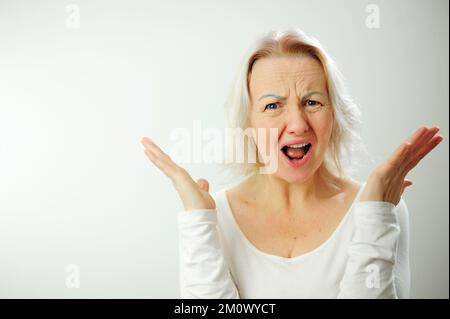 Donna adulta frustrato e furioso gesti grida donna arrabbiata urlando Screaming, odio, rabbia. Piangendo emotivo arrabbiato donna urlando femmina metà lunghezza ritratto. Emozioni umane Foto Stock