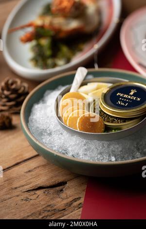 Una foto poco profonda di Tin of Caviar e Mini Pancakes su ghiaccio Foto Stock