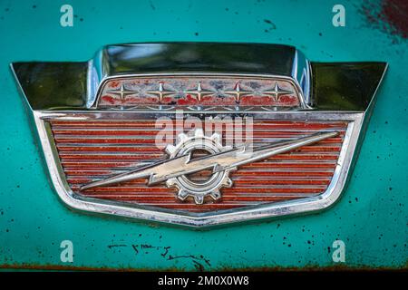 Des Moines, IA - 03 luglio 2022: Vista dettagliata ravvicinata di un emblema del cofano del pick-up Fleetside Ford F100 del 1965 in occasione di una fiera automobilistica locale. Foto Stock