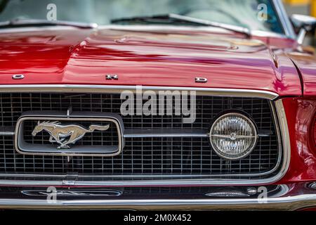 Des Moines, IA - 03 luglio 2022: Primo piano vista dettagliata di un faro e griglia Ford Mustang GT Coupe 1965 in una fiera automobilistica locale. Foto Stock