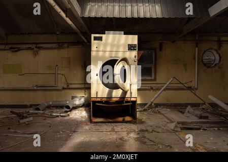 Asciugatore industriale in abbandonato, vandalizzato, derelitto, Ospedale, lavanderia Foto Stock