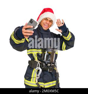 Il pompiere di Santa Hat prende un selfie Foto Stock
