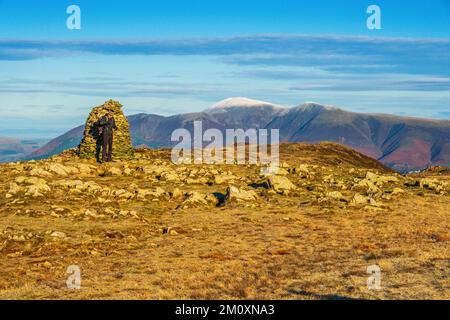 Un camminatore sulla cima di High Spy con Skiddaw in distanza, Lake District National Park Foto Stock