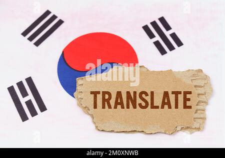 Concetto di business e finanza. Sullo sfondo della bandiera sudcoreana si trova il cartone con l'iscrizione - Traduci Foto Stock