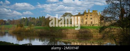 Vista panoramica dello storico Castello Ripley di grado 1 illuminato dal sole (vecchia torre d'angolo, giardini panoramici di campagna, giardini) - North Yorkshire, Inghilterra, Regno Unito Foto Stock