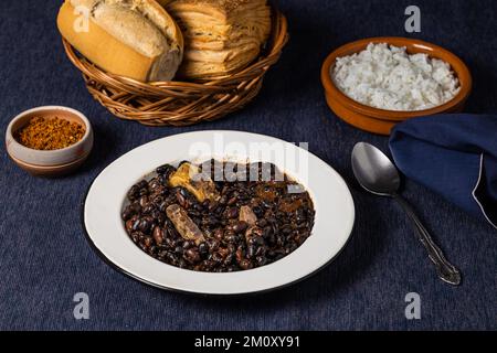 Fagioli e maiale, piatti tipici brasiliani, riso e pane. Foto Stock