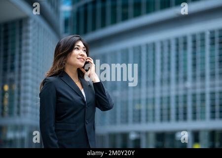 Affascinante ed elegante donna giapponese impegnata in una telefonata, concetto di successo nel business, riscatto e imprenditorialità di successo delle donne Foto Stock