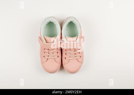 Graziose sneakers rosa per bambini. Sfondo bianco. Vestiti e scarpe per bambini. Piano, copia spazio Foto Stock