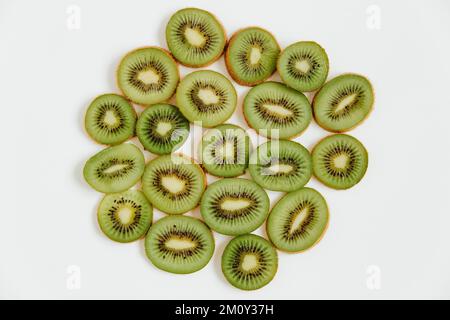Modello fruttato di kiwi e fette su fondo bianco. Concetto di cibo. Disposizione piatta, vista dall'alto, spazio di copia Foto Stock