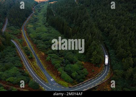 Vista aerea di un camion che attraversa una curva a forma di V sulla strada che porta ad una lacuna nelle montagne Knockmealdown a Clogheen, Tipperary, Irlanda. Foto Stock