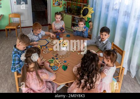 i bambini che giocano a un gioco da tavolo seduti al tavolo Foto Stock