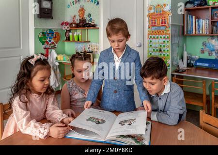 il ragazzo mostra il libro ai suoi amici Foto Stock