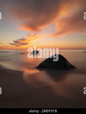 Tramonto sulle rocce costiere presso la spiaggia di Myrland, Isole Lofoten, Norvegia Foto Stock