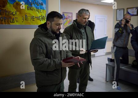 Kharkiv, Ucraina. 06th Dec, 2022. Il presidente ucraino Volodymyr Zelenskyy, a sinistra, e il consigliere per la sicurezza Nazionale Roman Mashovet, al centro, ha letto la citazione in quanto presenta farmaci da combattimento con medaglie durante una visita ad un ospedale militare il giorno delle forze armate dell'Ucraina, 6 dicembre 2022 a Kharkiv, Ucraina. Credit: Presidenza Ucraina/Ufficio stampa presidenziale Ucraina/Alamy Live News Foto Stock