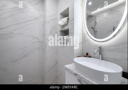 Interno bagno bianco con piastrelle in marmo alle pareti Foto Stock