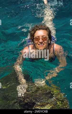 Hydra, Idra, Ύδρα, Grecja, Grecia, Griechenland; Una donna con bicchieri bagna nel mare; Eine Frau mit Brille badet im Meer; Kobieta kąpie się w morzu Foto Stock