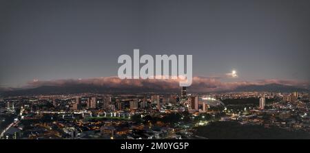 Luna che sorge su San Jose, Costa Rica Foto Stock