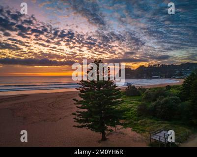 Alba aerea sul mare con nuvole rmedium che si estendono attraverso il cielo a Avoca Beach sulla costa centrale, NSW, Australia. Foto Stock