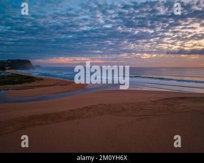 Alba aerea sul mare con nuvole medie che si estendono attraverso il cielo a Avoca Beach sulla costa centrale, NSW, Australia. Foto Stock