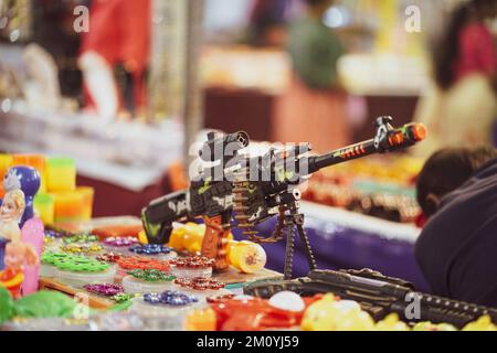 Una mitragliatrice giocattolo per bambini, una pistola giocattolo per bambini che vende sul mercato, centro commerciale, fiera, negozio Foto Stock