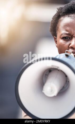 Non ci verrà negato. una giovane donna urla attraverso un megafono a una protesta. Foto Stock