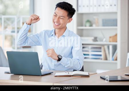 Non arrda mai fino a che non riuscite. un giovane uomo d'affari che allietava mentre usa un computer portatile al lavoro. Foto Stock