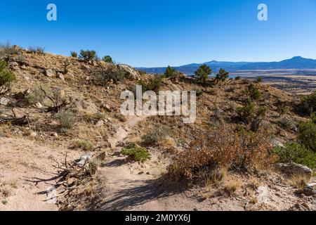 Sentiero escursionistico di Chimney Rock attraverso il deserto verso montagne lontane a Ghost Ranch, Abiquiu, New Mexico Foto Stock