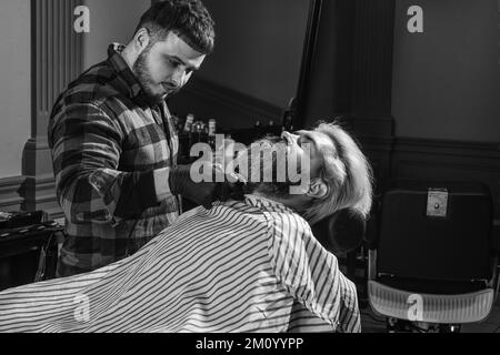 Barber è una risorsa essenziale per il vostro stile. Rasatura con il rasoio. Capelli del viso. Mantenere la forma della barba. Fai crescere barba e baffi. Uomo al barbiere Foto Stock