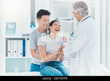 Che occasione gioiosa. una giovane coppia che parla con il proprio medico. Foto Stock