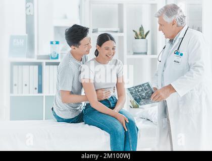 Youre aspettandosi un pacco di gioia. una giovane coppia che viene mostrato i loro ultrasuoni dal loro medico. Foto Stock