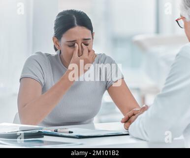 Questo non è la fine della strada. una giovane donna attraente seduta e tenendo la mano dei medici mentre la conforta in clinica. Foto Stock