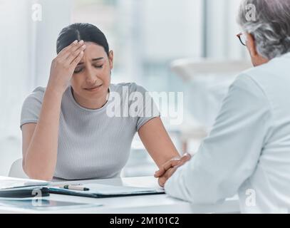 Non sia così duro su lei. una giovane donna attraente seduta e tenendo la mano dei medici mentre la conforta in clinica. Foto Stock