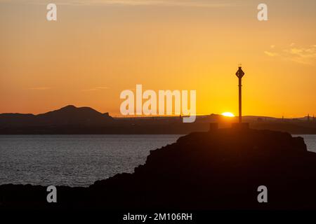 Dalgety Bay, Fife, Scozia. 09 dicembre 2022. Una giornata fredda in Scozia scaldata da un bellissimo tramonto sulla Arthur’s Seat di Edimburgo e su Downing Point a Dalgety Bay. © Richard Newton / Alamy Live News Foto Stock