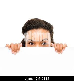 Nascondendosi dal suo proprio successo. una giovane donna d'affari che sbirciava da dietro un cartello sullo sfondo di uno studio. Foto Stock