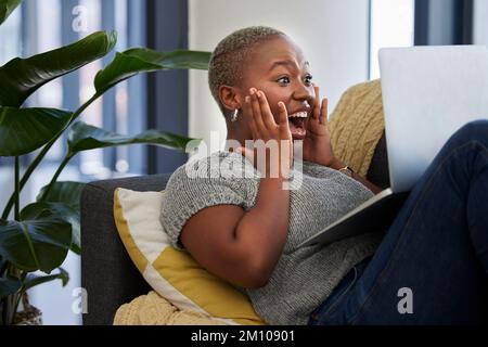 Laptop, sorpresa ed eccitata donna nera sul divano scioccato con la vittoria della lotteria digitale, della concorrenza o del premio. WOW notizie, vincitore del premio e ragazza su Foto Stock