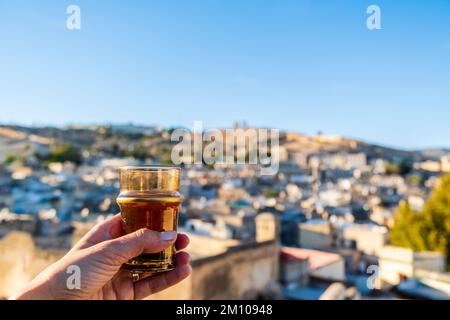 Delizioso tè alla menta tradizionale bevuto con la vista del centro storico chiamato medina a Fez, Marocco, Nord Africa Foto Stock