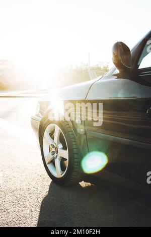 Ucraina, Chernihiv - 10 ottobre 2022: Vecchia auto svedese Saab 9-3 Aero sulla strada. Le luci di un sole Foto Stock