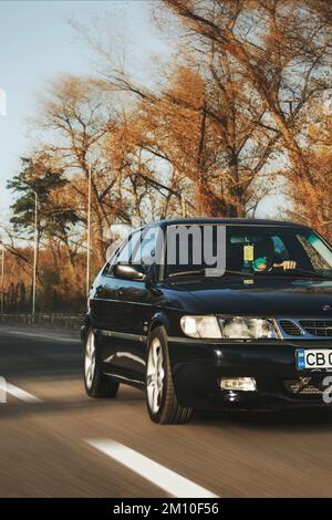 Ucraina, Chernihiv - 10 ottobre 2022: Vecchia auto svedese Saab 9-3 Aero sulla strada. Auto in movimento Foto Stock